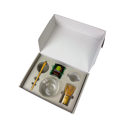 A complete Matcha Essentials Set by HARIO, featuring a double-walled glass bowl, bamboo chasen, and Maeda-en ceremonial matcha in an open white gift box