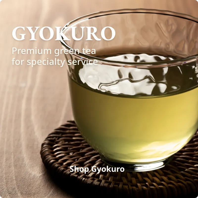 Glass of Gyokuro green tea with a wooden coaster on a beige background